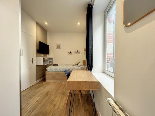 Cette petite chambre comprend une table et un lit. dans l'établissement Le Saint Michel - Studio proche gare, à Saint-Brieuc