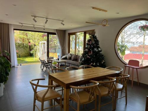 a living room with a wooden table and a christmas tree at Én Nhỏ Homestay Sa Pa in Sa Pa