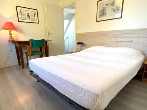 Ce lit se trouve dans un dortoir doté d'un bureau et d'une chaise verte. dans l'établissement Grande maison familiale à 200m de la plage avec jardin et WIFI à Trégastel - FR-1-368-457, à Trégastel