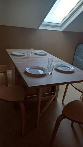 une table avec des assiettes et des verres au-dessus dans l'établissement Cosy app near sea, à Cabourg
