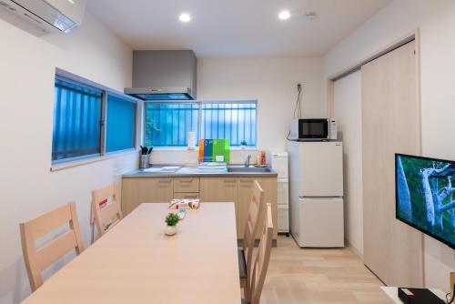 a kitchen with a table and a refrigerator at Y's INN アネックス 012T in Tokyo