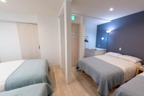 une chambre avec deux lits et un mur bleu dans l'établissement Y's INN アネックス 012T, à Tokyo