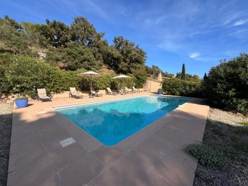 une piscine avec chaises et parasols dans l'établissement La Bergerie, à Saint-Raphaël
