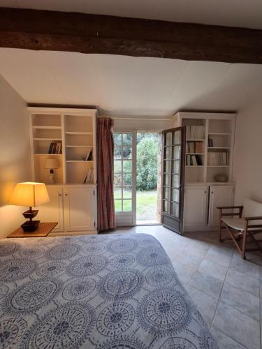 a bedroom with a bed and a table and a window at La Bergerie in Saint-Raphaël