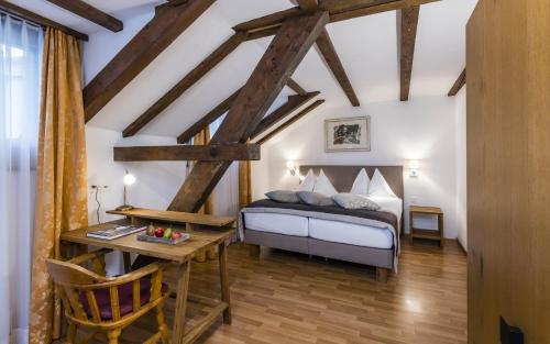 a bedroom with a bed and a desk in a room at Hotel Stern Chur in Chur