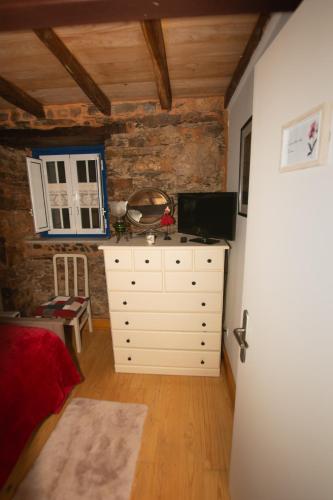 a bedroom with a white dresser and a window and a room at Casa da Mata de Fajão in Pampilhosa da Serra