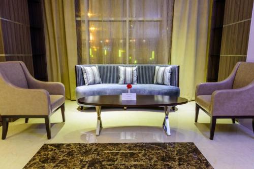 a living room with a couch and two chairs at National Park Hotel in Baljurashi