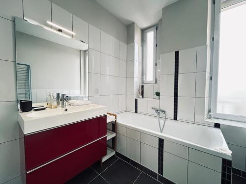 une salle de bain avec une baignoire et un lavabo et une baignoire dans l'établissement Neufchatel superbe appartement 3 chambres, à Reims