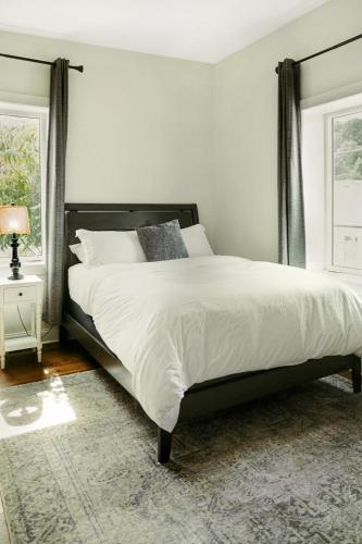 a bedroom with a bed with white sheets and a rug at Spacious Freshly Renovated Townhome - City Side in Loudon