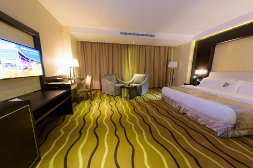 a hotel room with a large bed and a flat screen tv at National Park Hotel in Baljurashi