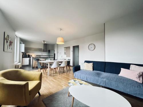 un salon avec un canapé bleu et une table dans l'établissement Neufchatel superbe appartement 3 chambres, à Reims