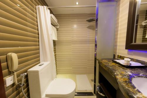 a bathroom with a toilet and a sink at National Park Hotel in Baljurashi