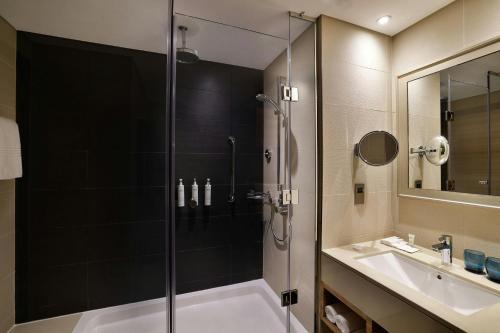 a bathroom with a shower and a sink at Courtyard by Marriott World Trade Center, Abu Dhabi in Abu Dhabi