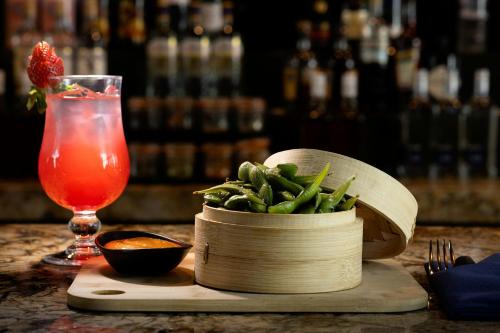 a table with a bowl of green beans and a drink at Courtyard by Marriott World Trade Center, Abu Dhabi in Abu Dhabi