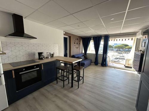 une cuisine et un salon avec une table et des chaises dans l'établissement Appartement rénové, 4 couchages, proche plage et commerces, parking privé, Port Camargue - FR-1-250-44, au Grau-du-Roi