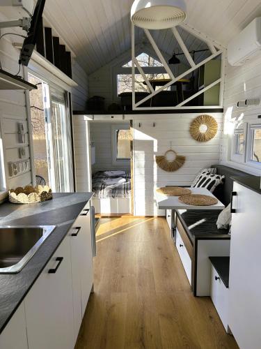 a kitchen with white cabinets and black counter tops at Półwysep Zacisze - Tiny House Village in Przywidz