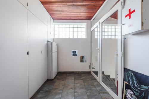a hallway with white walls and a red cross on the wall at 'Easy Steps' Guesthouse - Room 3 - Pro Bono in Shkodër
