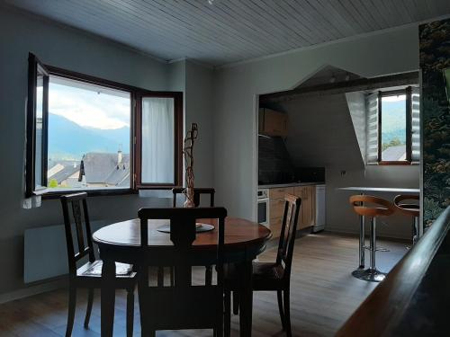 une cuisine et une salle à manger avec une table et des chaises dans l'établissement Appartement calme dans maison avec jardin, à Argelès-Gazost