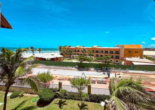 a resort with a pool and the ocean in the background at Vista Mar Deslumbrante! Apê na Areia confortável e espaçoso no Porto das Dunas, Ideal para Famílias in Aquiraz