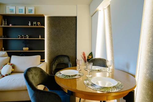 a dining room with a table and chairs and a couch at The QUARK Modern Designed 2BR Central Apartment in Craiova
