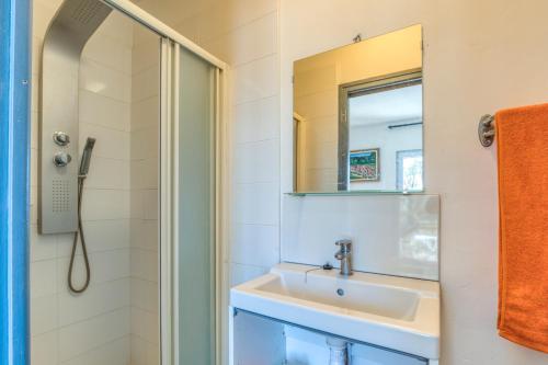 un baño con lavabo y espejo en Appartement 4 personnes, en Balaruc-le-Vieux