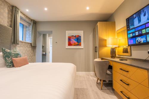 a bedroom with a bed and a desk and a television at Ambleside Townhouse in Ambleside