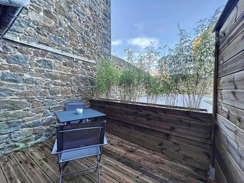 un gril posé sur une terrasse en bois à côté d'un mur de briques dans l'établissement Studio le Glinglin - proche gare, à Saint-Brieuc