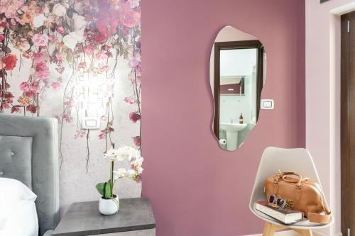 a bedroom with a pink wall with a mirror at B&B Golden House & spa in Rose