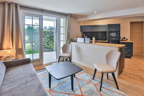 a living room with a kitchen with a counter and chairs at Cozy apartment in Port Bourgenay in Talmont