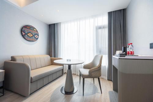 a living room with a couch and a table and chairs at Lijiang OKDAY HOTEL in Lijiang