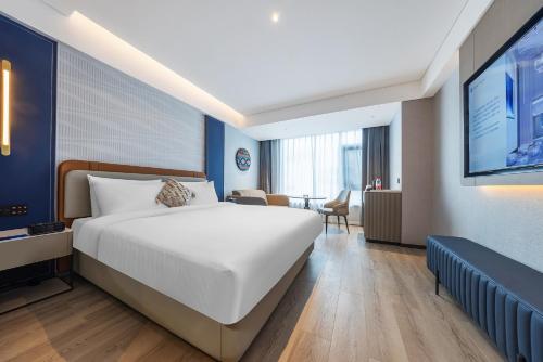a hotel room with a bed and a television at Lijiang OKDAY HOTEL in Lijiang