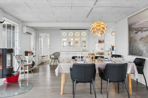 a kitchen and dining room with a table and chairs at Feriehus 1103 in Ringkøbing
