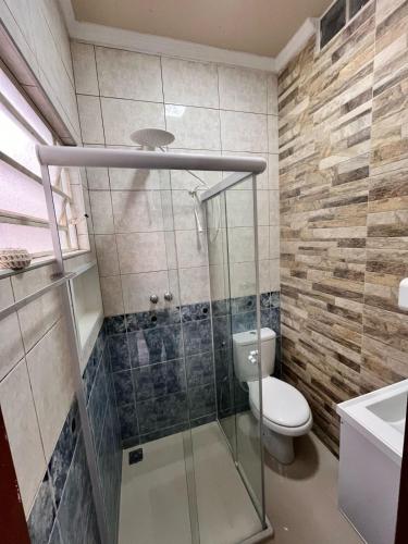 a bathroom with a toilet and a glass shower at Loft microcasa em Altos da Cidade - perto de tudo in Bauru