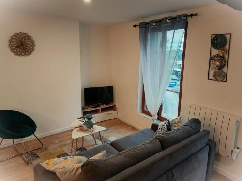 ein Wohnzimmer mit Couch und großem Fenster in der Unterkunft Paris & Disney - LES BORDS DE MARNE in Meaux
