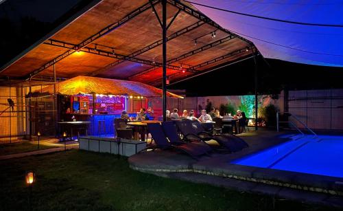 a group of people sitting around a pool at night at Parrot Resort Moalboal in Moalboal