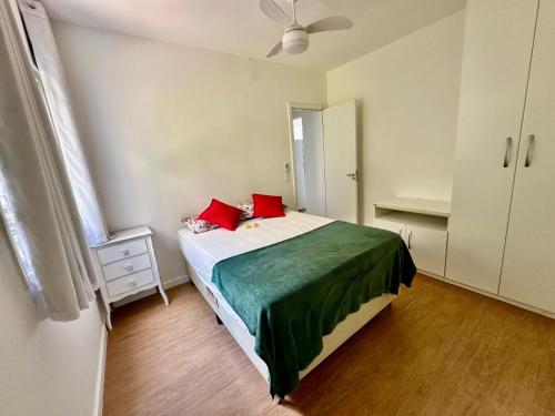 a bedroom with a bed with red pillows on it at Apartamento Bela Vista Porto Real Resort in Mangaratiba