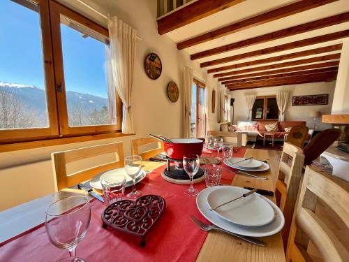 une table de salle à manger avec des assiettes et des verres dessus dans l'établissement Chalet rénové à Samoëns - Calme et confort avec terrasse - FR-1-624-178, à Samoëns