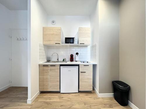 une petite cuisine avec un évier et un réfrigérateur dans l'établissement Studio la Ville Jouha - proche gare, à Saint-Brieuc