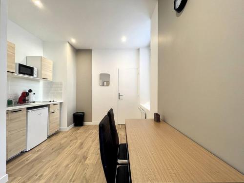 une cuisine avec une table et des chaises dans une pièce dans l'établissement Studio la Ville Jouha - proche gare, à Saint-Brieuc