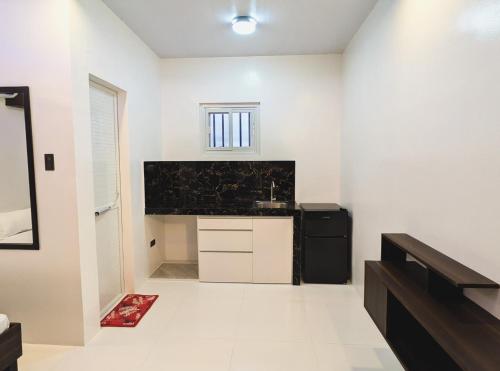 una cucina con pareti bianche e un apparecchio nero di Guestway Transient Inn a Calapan