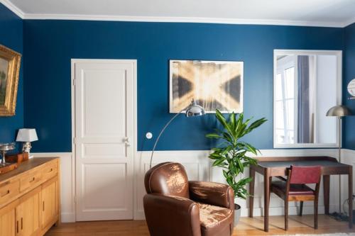 une salle à manger avec des murs bleus, une table et une chaise dans l'établissement Nice refurbished T2 near Place du Trocadéro, à Paris