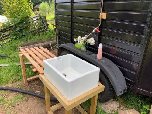 a white sink sitting on a table next to a bench at Self Contained Yurt - Barbadoes in Tintern