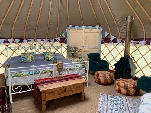 a bedroom with a bed and a stove in a yurt at Self Contained Yurt - Barbadoes in Tintern