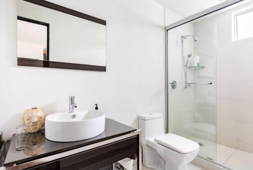 a white bathroom with a sink and a toilet at Habitación confortable dentro departamento Natura in Mexico City