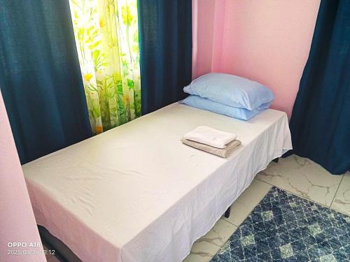 a small bed with two towels on top of it at MW UrbanTerrace 2 Surigao del Norte in Surigao