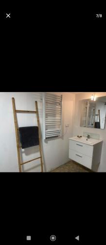 Cette chambre comprend un bureau, une chaise et un lavabo. dans l'établissement Studio à la campagne, à Cordemais