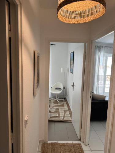un couloir menant à un salon avec un lustre dans l'établissement Bel appartement au calme hyper centre Nice, à Nice