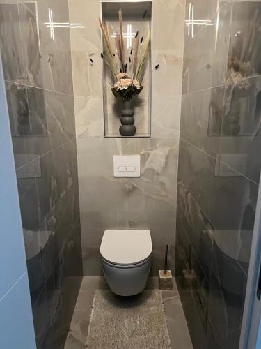 La salle de bains est pourvue de toilettes et d'un vase de fleurs. dans l'établissement Appartement au cœur de Vannes, à Vannes