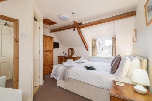 a bedroom with a bed and a desk and a window at The Royal Oak in Gillamoor
