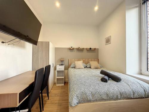 une chambre avec un lit, une table et des chaises dans l'établissement studio Le Robien - Proche Gare, à Saint-Brieuc